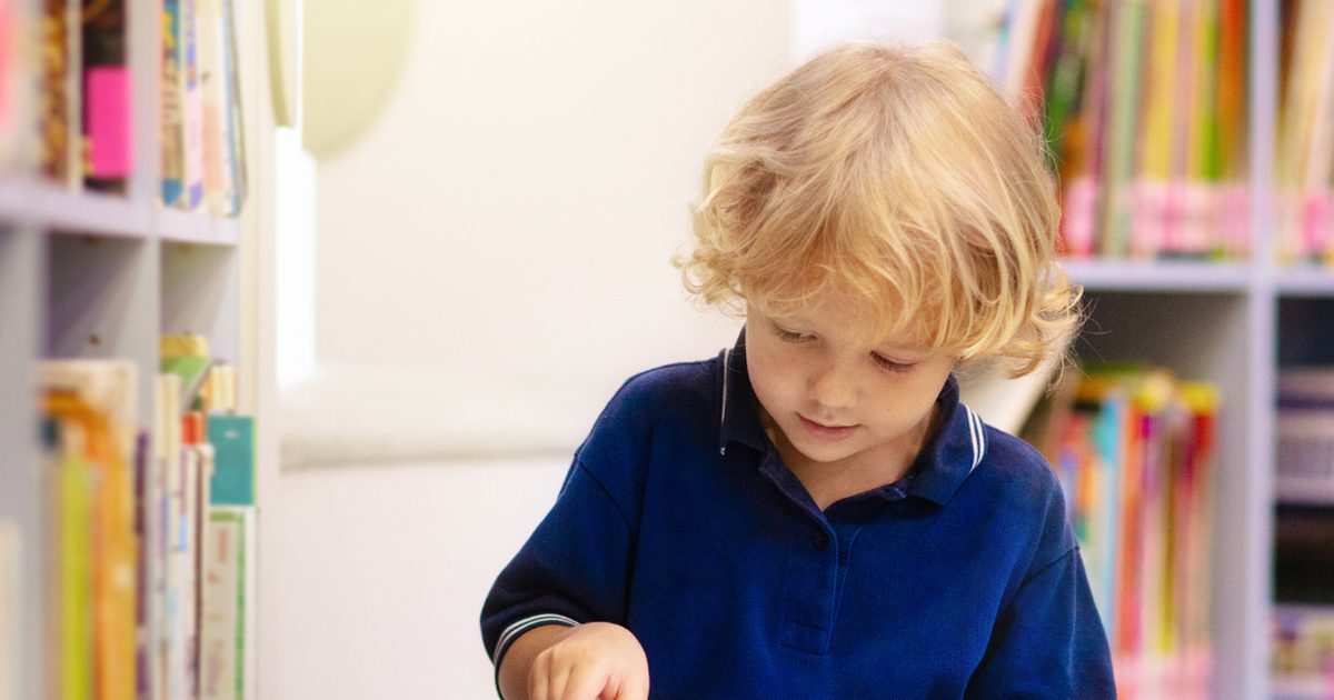 Enfant concentré sur un livre illustré