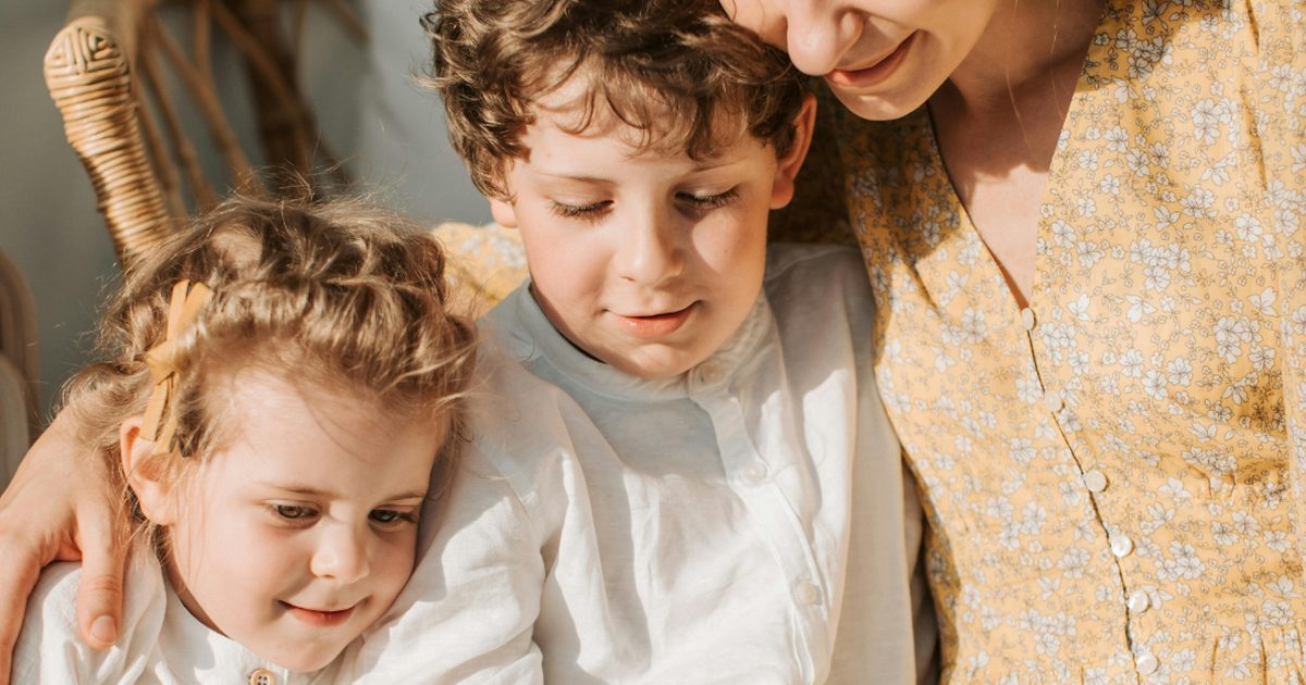 Mère et enfants lisant un livre ensemble